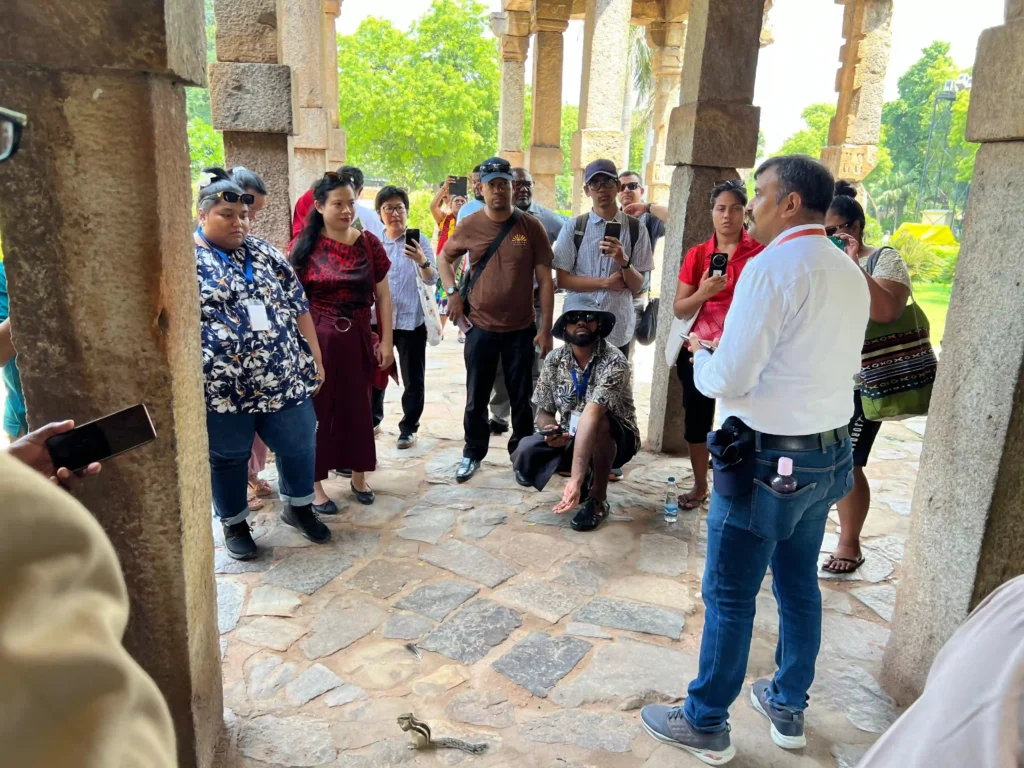 Government-approved heritage guide explaining the history and architecture of Qutub Minar to visitors during a private heritage tour in Delhi.